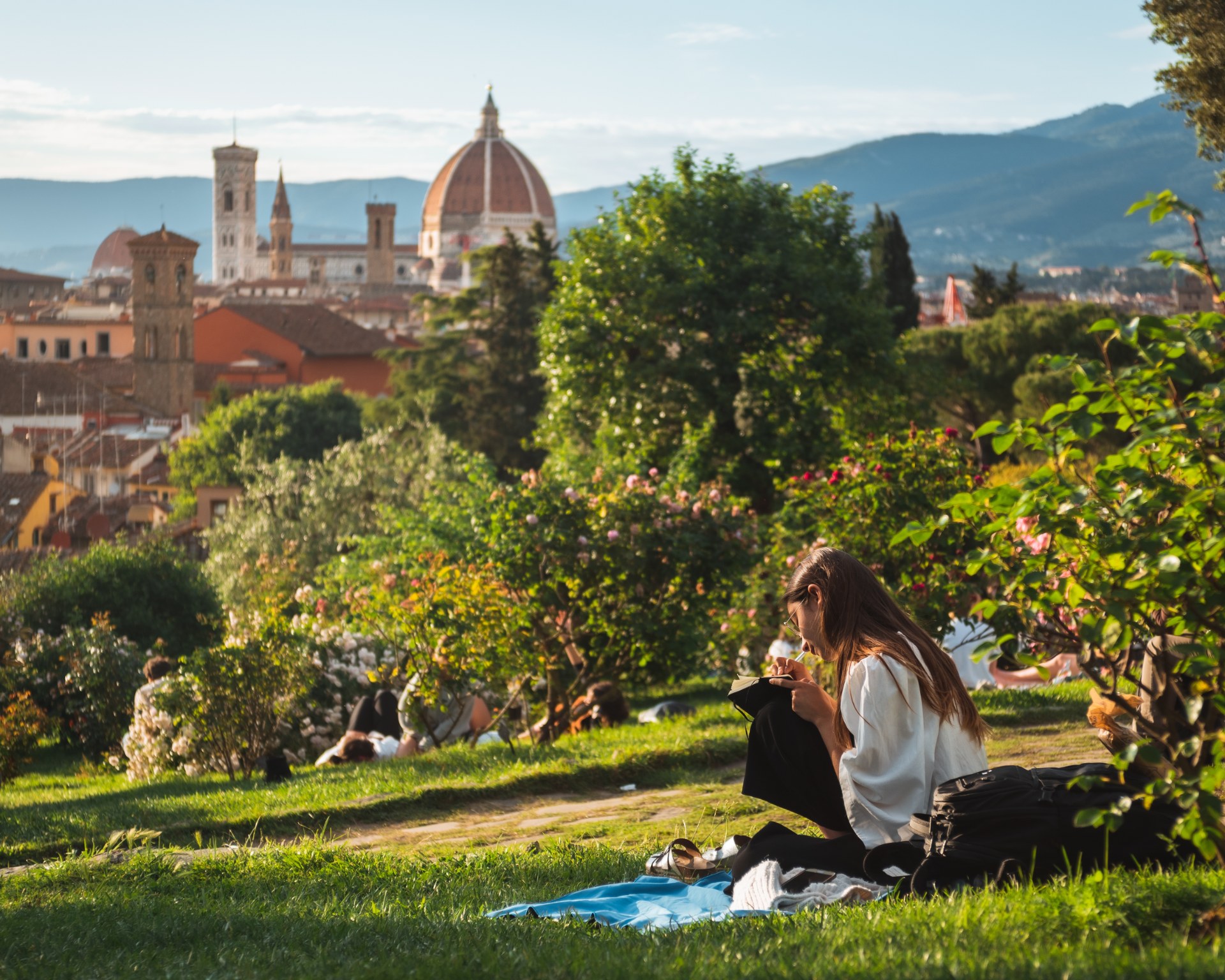 Jovem a ler na relva, com vista sobre Florença